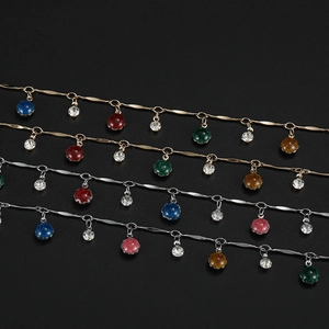 Dettaglio di ciondoli in resina glitterata colorata e cristalli su catene placcate oro e argento