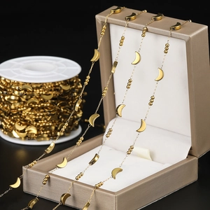 Detailed macro of golden crescent moon and bead chain for DIY jewelry making