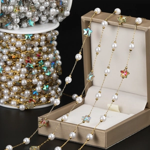 Detail of 18K gold plated chain with white pearls and iridescent acrylic stars for DIY jewelry