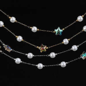 Detailed macro view of 18K gold and silver plated chains with pearls and acrylic stars