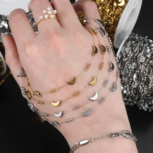 Detail of vacuum plated stainless steel moon and star charm chains in gold and silver