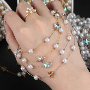 Detail of 18K gold and silver plated chain with acrylic laser stars and white pearls