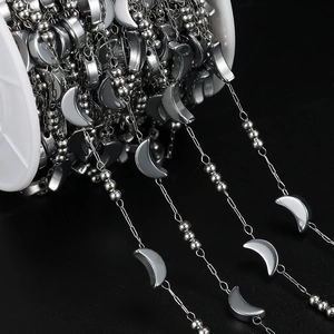 Macro detail of silver moon and star stainless steel chain spool for DIY jewelry