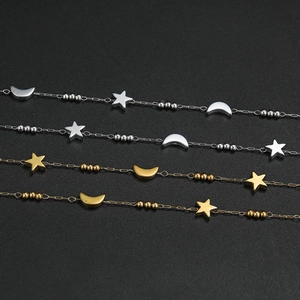 Detail of stainless steel star and moon charms with beads on gold and silver chains