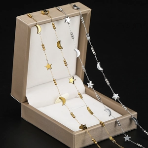 Detailed view of gold and silver star and moon chain bracelets on jewelry box
