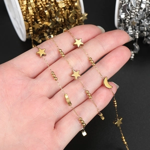Detailed view of handmade stainless steel chain with gold star and moon charms