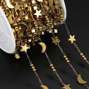Detail of gold vacuum plated stainless steel star and moon bead chain on a spool
