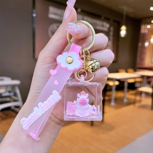 Close-up of pink Capybara liquid glitter keychain with Sweet Heart silicone wristband