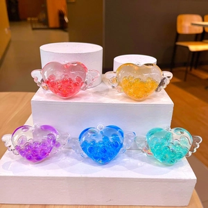 Dettaglio di ciondoli a cuore alato con perline mobili in cinque vivaci colori caramella