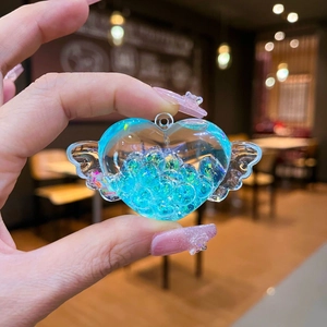 Dettaglio portachiavi a cuore con ali d'angelo e glitter liquidi blu scintillanti