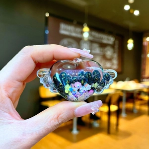 Dettaglio portachiavi a cuore alato con perline nere glitterate e piccoli fiori