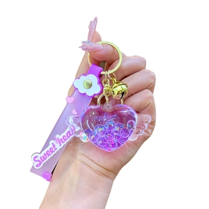 Portachiavi cuore viola luminoso con ali, glitter liquidi e campanello d'oro sul cinturino