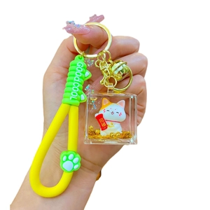 Lucky cat acrylic keychain with yellow strap and golden glitter floating inside a cube