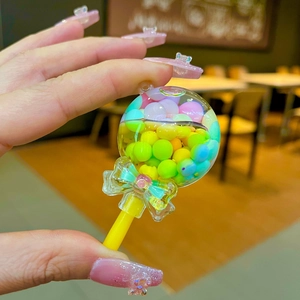 Close-up of colorful liquid sand lollipop pendant with small beads and blue bow detail