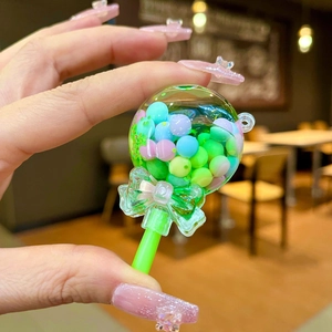 Close-up of a lollipop keychain with macaron colored beads and a green bow