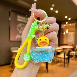 Macro detail of a yellow duckling inside a clear star-filled bathtub keychain charm