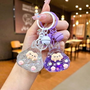 Detail of glittery rabbit acrylic keychains with floating petals and tiny bells