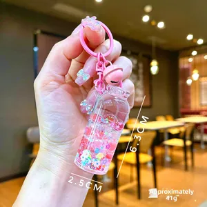Close-up of cute acrylic quicksand bottle keychain with stars and pink bell ornament