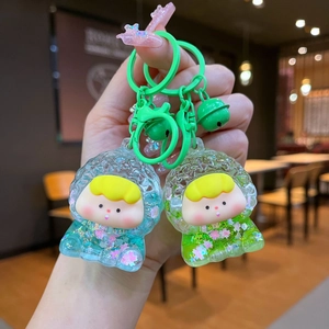 Macro detail of acrylic liquid sand keychains with cute doll figures and bells