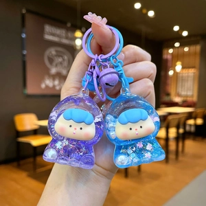 Close-up of cute purple and blue liquid sand astronaut keychains with glitter and bells