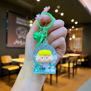 Detail view of cartoon liquid quicksand keychain with colorful glitter and green bell