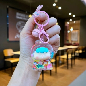 Close-up of cute acrylic liquid sand keychain with colorful fruit charms and a pink bell