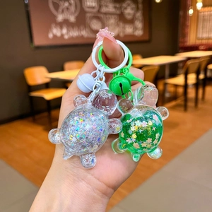 Close-up of cute turtle keychains with sparkling sequins and colorful mini bells