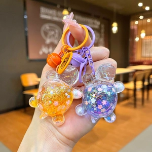 Close-up of glittery turtle keychains with colorful sequins and cherry blossom petals