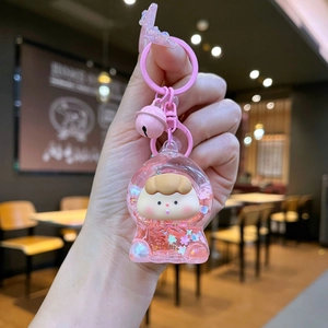 Detail of cute pink cartoon liquid quicksand keychain with star sequins and tiny bell