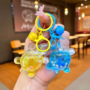 Close-up of cute glitter liquid sand turtle keychains in yellow and blue acrylic