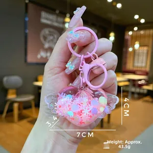 Close-up of pink heart winged keychain showing glitter liquid sand and 7cm dimensions