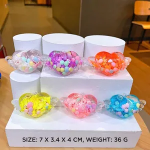 Close-up of heart-shaped resin charms with wings and colorful sequins in six colors