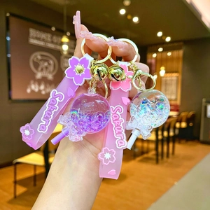 Detail of pink Sakura keychain with oil-filled bubble bead and glitter liquid ball charm