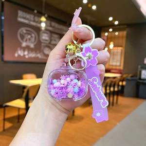Handheld view of Sakura themed keychain with purple silicone wristlet and sequins
