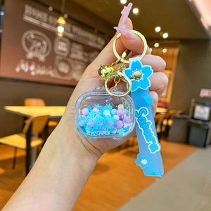 Detail of liquid sand keychain with blue snowflakes and Sakura print silicone strap