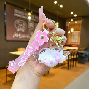 Detail of Sakura themed keychain with pink heart liquid glitter and silicone wristband