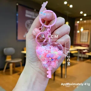 Pink heart-shaped quicksand bottle keychain with snowflakes and bell details