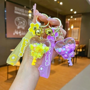 Acrylic heart liquid sand keychain with Sakura wrist strap and bell charm in yellow and purple