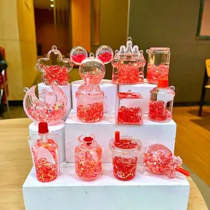 Détail de pendentifs rouges remplis de liquide, étoiles dorées et perles de sac