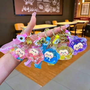 Detail of bear-shaped liquid glitter keychain with sweet heart strap and golden bell