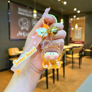 Detail of cartoon bear keychain with yellow resin doll and pink Sweet Heart strap