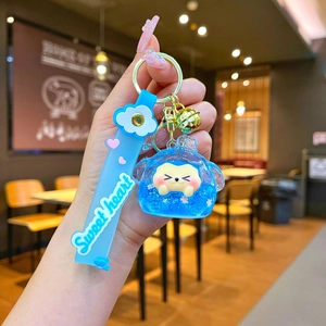 Close-up of blue silicone strap and golden bell detail on cartoon animal keychain