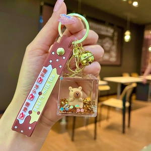 Close-up of Capybara milk tea keychain with floating glitter and brown rubber wrist strap