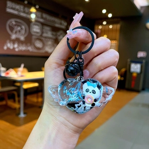 Gros plan d'un porte-clés panda en forme de cœur avec paillettes bleues et cloche