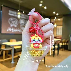 Detailed view of cartoon dragon keychain with golden sycee and red metal accessories