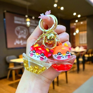 Cartoon dragon keychain with gold ingots, quicksand design, and festive lucky charms