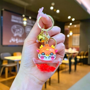 Detail of dragon keychain with a clear ingot base containing red sequins and lucky coins