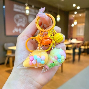 Close-up of ice cream cone keychain with colorful liquid sand and vibrant metal bells
