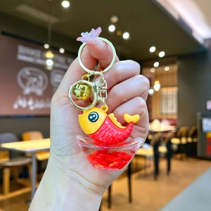 Detailed close-up of a lucky koi fish keychain with golden ingot and red bell accessory