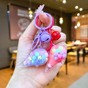 Detail of cute ice cream cone keychains with colorful liquid glitter and bell charms